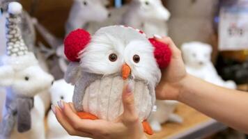 soft toy owl Putting toy owl under Christmas tree. Decorating home in winter. Xmas decor on window sill. POV arrange Christmas tree ornaments. Film grain pixel texture. Soft focus. Blur. Live camera video