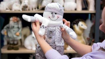 holding a silver snowman toy store choosing a christmas gift under the tree video