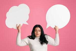 Complex Desicion. Puzzled Obese Girl Holding Two Empty Speech Bubbles Above Her Head And Looking At Camera, Panorama photo