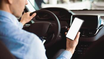 Smart Driving App. Man Using Smartphone Sitting In New Car Buying Vehicle In Auto Center. Selective Focus, Mock up photo