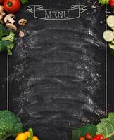 Design concept for restaurant menu mockup. Black rustic chalkboard with white inscription and vegetables frame, top view, copy space for text and logo, vegetarian cafe concept photo