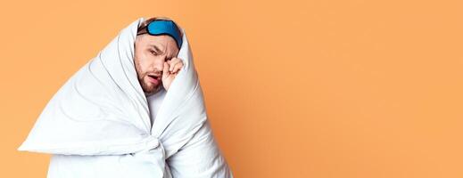 Man in blanket at studio. Hiding from the light, panorama, free space photo