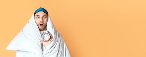 Young man does not want get up for work on yellow background photo