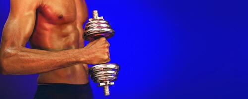 Bodybuilding Workout. Unrecognizable Strong Muscular Man Exercising With Dumbbells Over Blue Background In Studio, Focus On Dumbbell. Panorama photo
