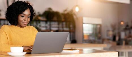 Female entrepreneur chatting with clients on laptop, drinking coffee and working at cafe, empty space photo