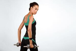 Determined Afro Girl Working Out With Dumbbells On Yellow Studio Background. Strength Exercises Concept. Free Space photo