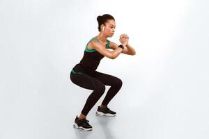 Afro Lady In Fitwear Exercising Doing Deep Squat Working Out On Yellow Background. Studio Shot photo