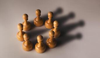 Wooden chess pawn circle with shadow shaped as crown on gray background. Teamwork, group agreement and success concept photo