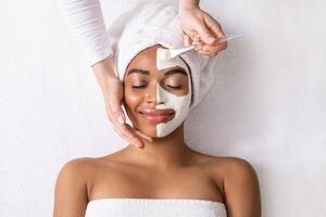 Black woman having white clay mask on half of her face, top view photo