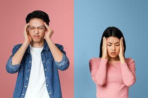 Got sick. Asian sad couple having headache, touching their temples over grey background photo
