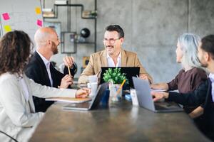 A group of professionals engaged in a lively discussion around a conference table in a contemporary office. Each member contributes ideas with enthusiasm, fostering collaboration. photo