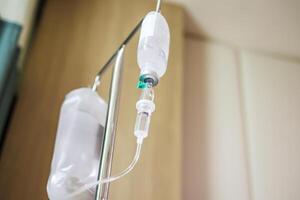 Close up medical intravenous IV drip in hospital background photo