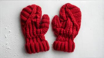A pair of red mittens on a white surface photo