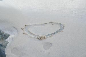 Heart drawn on the beach sand photo