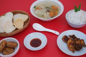 traditional Indonesian food arranged neatly on a red surface photo