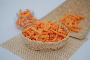 Crispy Corn Puffs in rattan on bamboo mat. Selective focus. photo