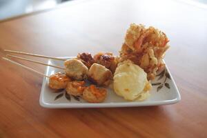 fried dumpling in a white plate on wooden table photo