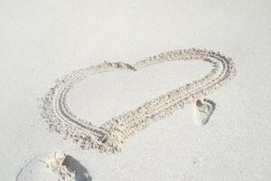Heart drawn on the beach sand photo