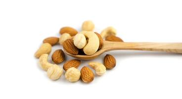 Mix of nuts in wooden spoon isolated on white background. Banner. Close-up. photo
