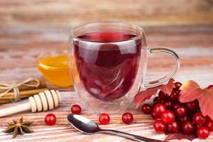Healthy tea from viburnum with honey on a wooden table. Seasonal vitamin drink. Close-up. Selective focus. photo