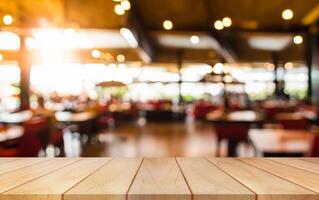 Empty wooden table top with lights bokeh on blur restaurant background. photo