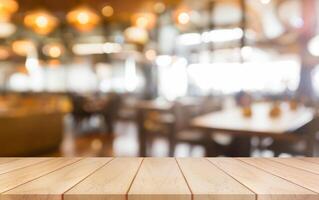 Empty wooden table top with lights bokeh on blur restaurant background. photo