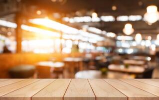 Empty wooden table top with lights bokeh on blur restaurant background. photo