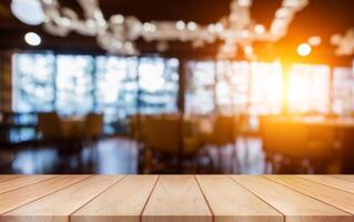 Empty wooden table top with lights bokeh on blur restaurant background. photo