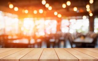Empty wooden table top with lights bokeh on blur restaurant background. photo