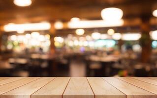 Empty wooden table top with lights bokeh on blur restaurant background. photo