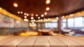 Empty wooden table top with lights bokeh on blur restaurant background. photo