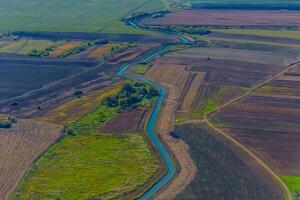 Aerial view of valley with farm fields, pond and Danube river. High quality photo