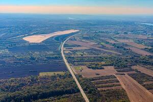 Aerial view of valley with farm fields, pond and Danube river. High quality photo