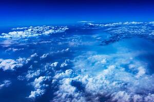 Aerial view from airplane window above green ground. View from the airplane window with beautiful clouds at sunrise. Earth and sky as seen through window of an airplane. photo