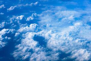 Aerial view from airplane window above green ground. View from the airplane window with beautiful clouds at sunrise. Earth and sky as seen through window of an airplane. photo