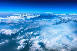 Aerial view from airplane window above green ground. View from the airplane window with beautiful clouds at sunrise. Earth and sky as seen through window of an airplane. photo