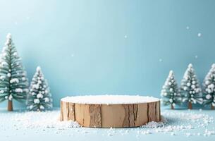 Winter-themed wooden pedestal with snow and miniature pine trees on blue background photo