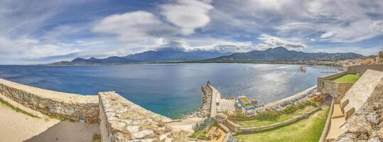 View from the fortress of Calvi in Corsica overlooking the coastline and the sea with mountains photo