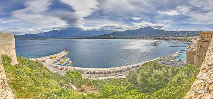 View from the fortress of Calvi in Corsica overlooking the coastline and the sea with mountains photo