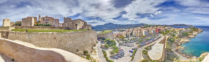 View from the fortress of Calvi in Corsica overlooking the coastline and the sea with mountains photo