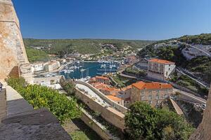 View from Bonifacios gate over the vibrant harbor with yachts, surrounded by historic buildings and cliffs photo
