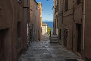 Quiet alley in an old Corsican mountain village with stone walls and rustic architecture photo