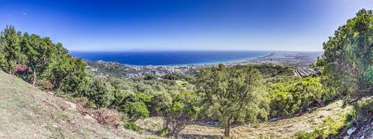 Panoramic view of Bastia and the Corsican coastline from the lush mountains in the hinterland photo