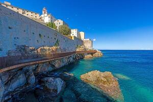Scenic view of Bastia harbor and historic promenade with colorful buildings under a clear blue sky photo