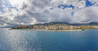 Panoramic view of Bastia Corsica from the sea with colorful buildings under dramatic cloudy skies photo