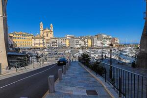 Scenic view of Bastia harbor and historic promenade with colorful buildings under a clear blue sky photo