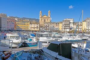 Scenic view of Bastia harbor and historic promenade with colorful buildings under a clear blue sky photo