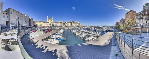 Scenic view of Bastia harbor and historic promenade with colorful buildings under a clear blue sky photo