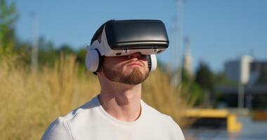 A man wearing a white shirt and headphones is wearing a virtual reality headset video
