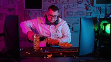 A man sitting at a desk with a computer and a bowl of popcorn video